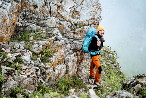 The guy climbed the rock alone, mountain hiking extreme sport, hard climbing, hiking with a backpack in the mountains, trekking