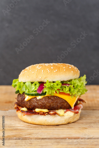 Hamburger Cheeseburger fastfood fast food on a wooden board portrait format © Markus Mainka