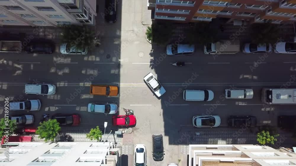 Aerial view of the city traffic at the center. Vehicles are moving between buildings. Aerial view of the city traffic at the center. Vehicles are moving between buildings.