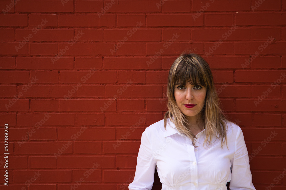 Pretty, blonde, young woman having fun making different expressions in front of a red background wall. Concept various expressions. Laughter, sadness, tired, angry, hate. Pretty, blonde, young woman having fun making different expressions in front of a red background wall. Concept various expressions. Laughter, sadness, tired, angry, hate.