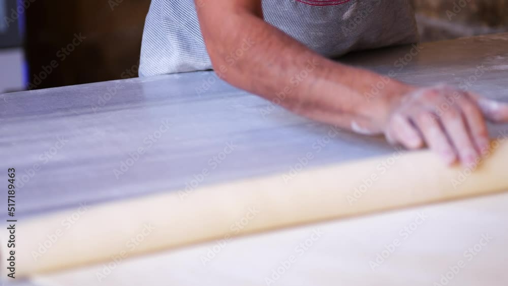 Baker Using Long Thin Rolling Pin To Roll Fresh Dough Baker Using Long Thin Rolling Pin To Roll Fresh Dough