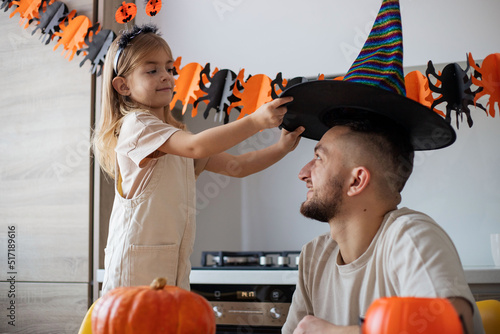 Happy family father and daughter preparing for Halloween, having fun.