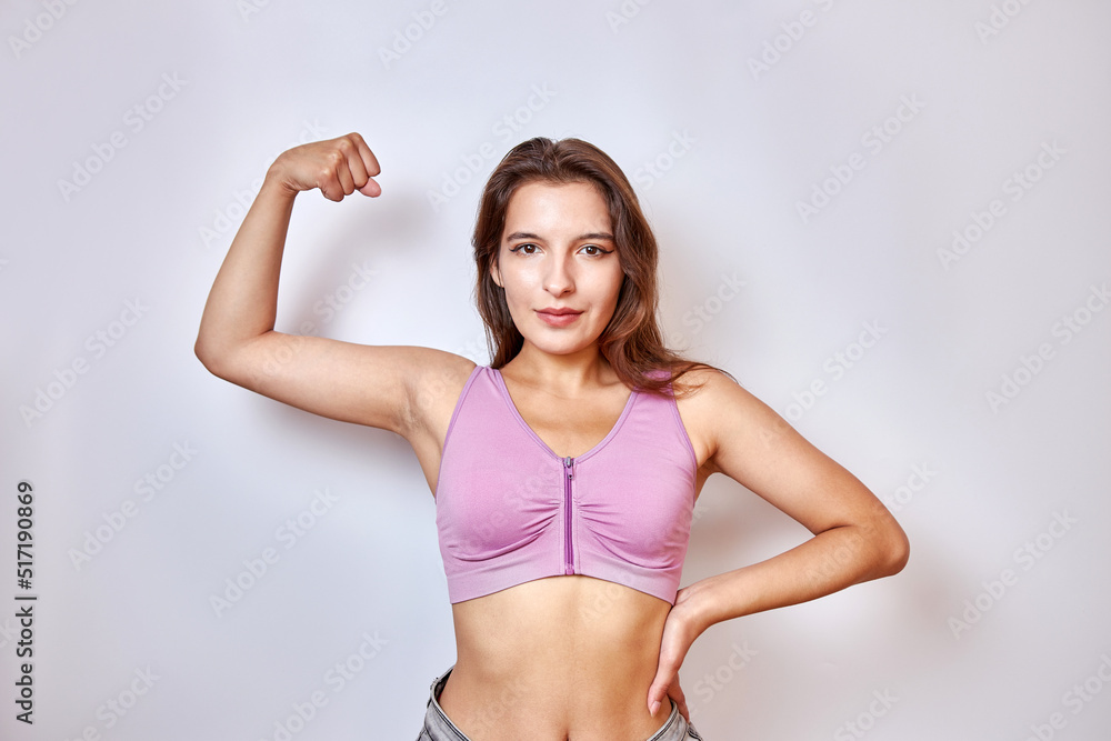A beautiful girl raised her hand and strained her biceps. The concept of fitness. A beautiful girl raised her hand and strained her biceps. The concept of fitness.