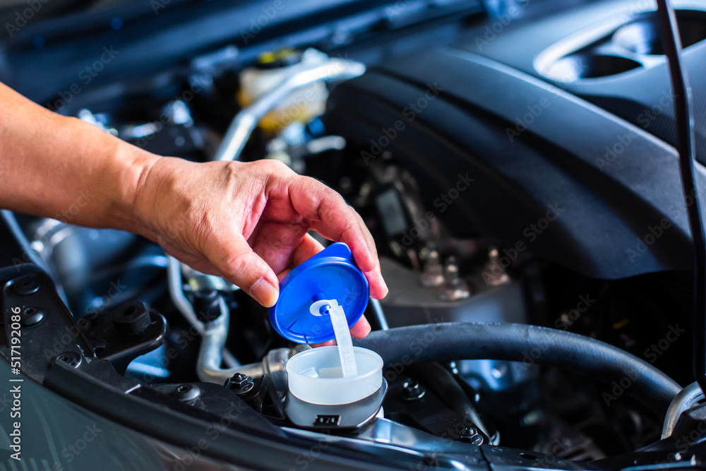 Mechanic fill fresh water into windscreen or in water tank wiper on car