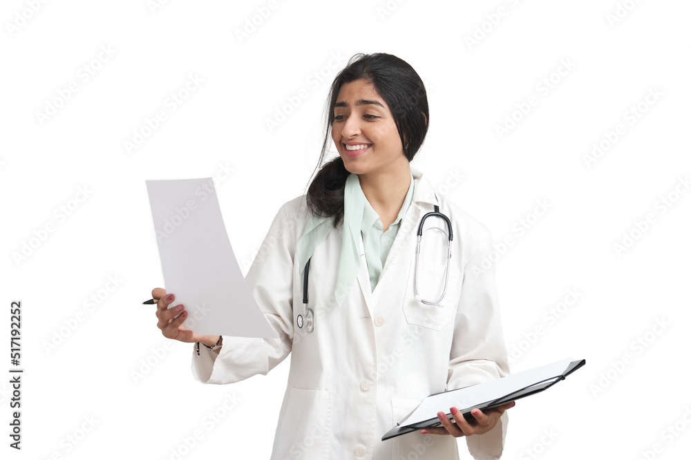 Young Venezuelan female doctor reading a medical report and smiling. Isolated over white background. Young Venezuelan female doctor reading a medical report and smiling. Isolated over white background.