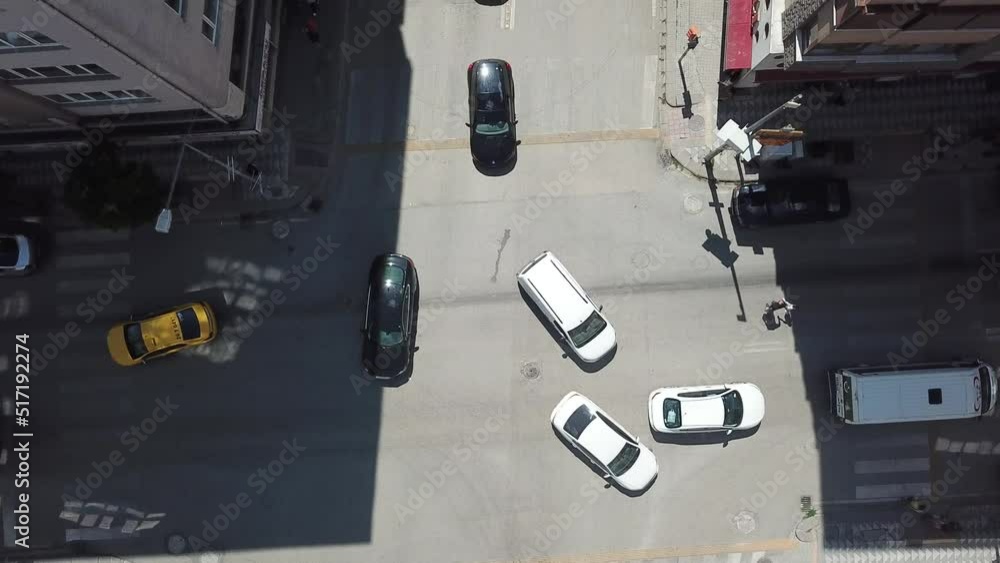 Aerial view of the city traffic at the center. Vehicles are moving between buildings. Aerial view of the city traffic at the center. Vehicles are moving between buildings.