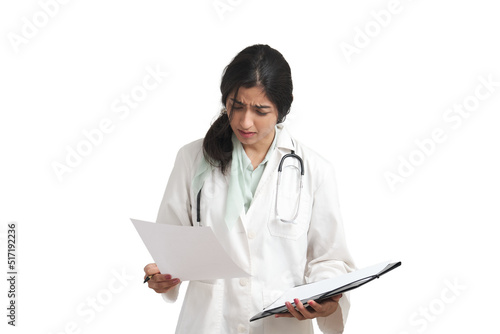 Young Venezuelan female doctor frown reading a medical report. Isolated over white background. photo