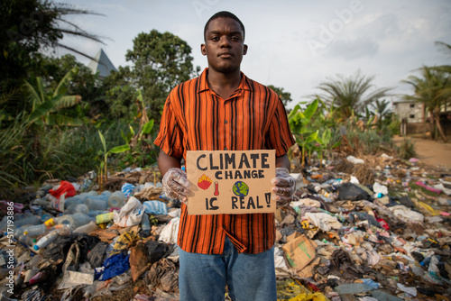 African boy holds a sign in his hand with the words: 