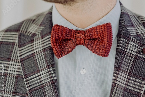 Fototapeta Closeup of a male wearing red bow tie and checkered gray blazer