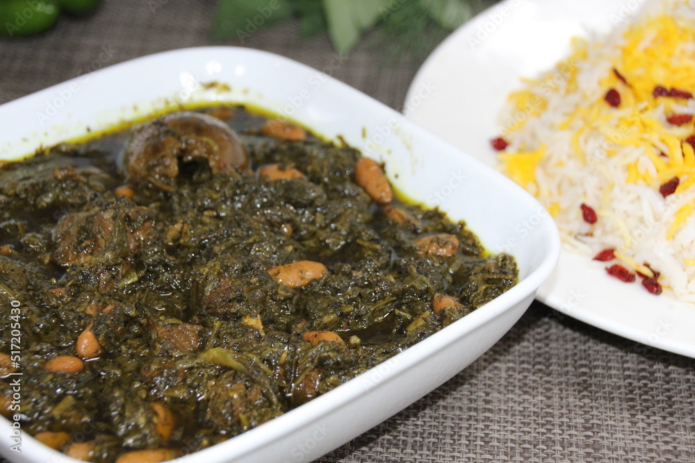 Ghormeh Sabzi or mixed vegetables served in a dish isolated on wooden background side view Ghormeh Sabzi or mixed vegetables served in a dish isolated on wooden background side view