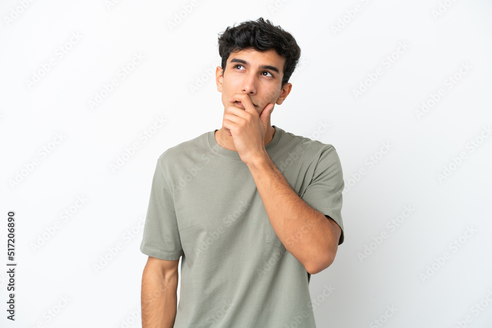 Young Argentinian man isolated on white background having doubts and with confuse face expression Young Argentinian man isolated on white background having doubts and with confuse face expression
