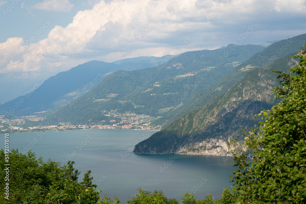 Panorama at Lake Iseo and mountains around at sunny day with clouds. Bergamo, Lombardy, Italy.