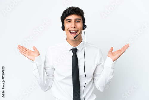 Telemarketer man working with a headset isolated on white background with shocked facial expression