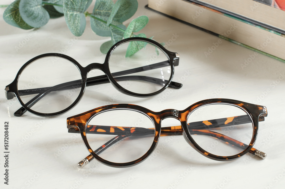Stylish female glasses on white wooden table Stylish female glasses on white wooden table