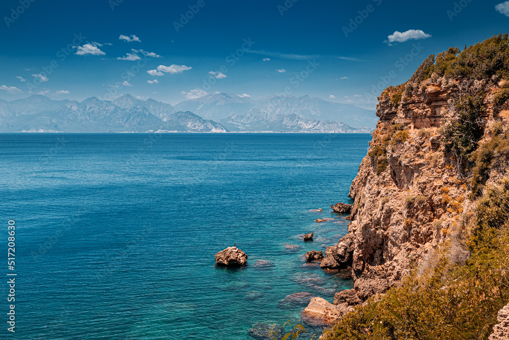 Aerial scenic panoramic seascape view with a high cliff. Vacation background and coastline concept. Azure sea bottom and transparent waters