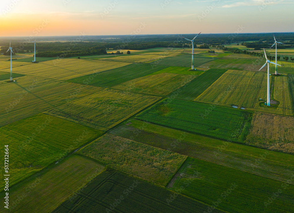 Obraz premium Aerial drone view of wind power turbines, part of a wind farm. Wind turbines on green field in countryside. Wind power plant.