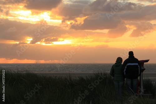 people watching the sunset on the north sea