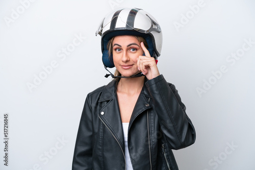 Young caucasian woman with a motorcycle helmet isolated on white background thinking an idea © luismolinero