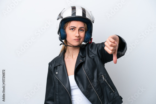 Young caucasian woman with a motorcycle helmet isolated on white background showing thumb down with negative expression