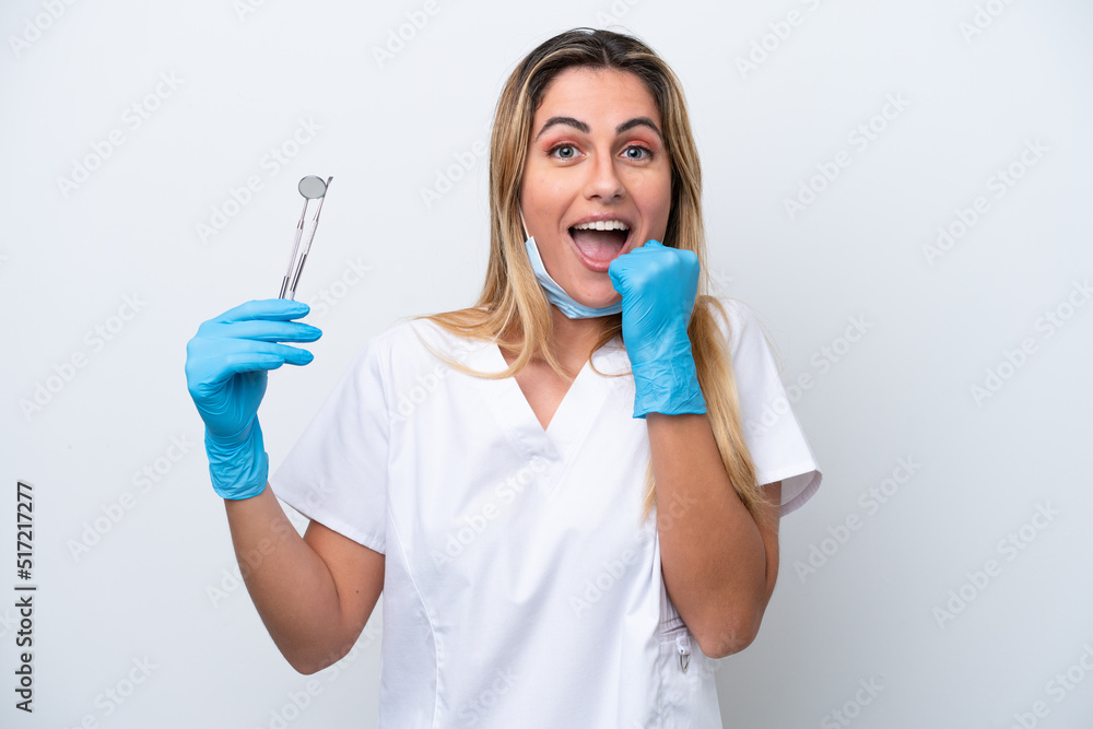 Dentist woman holding tools isolated on white background celebrating a victory in winner position Dentist woman holding tools isolated on white background celebrating a victory in winner position