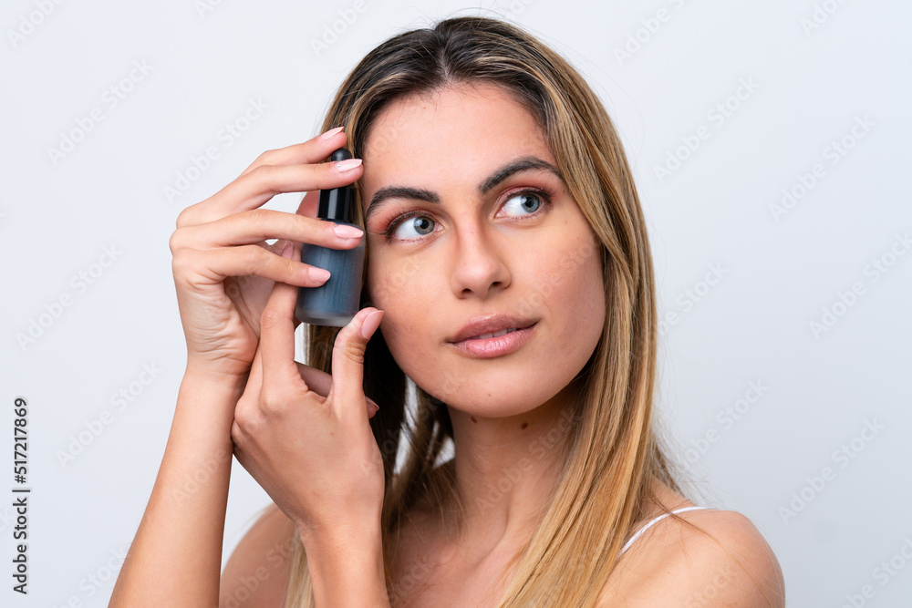 Young caucasian woman isolated on white background holding a serum. Close up portrait Young caucasian woman isolated on white background holding a serum. Close up portrait
