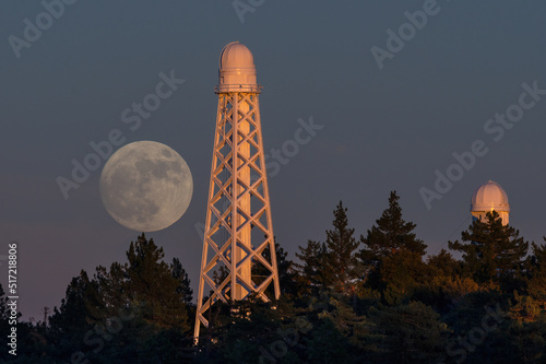 View from the San Gabriel Mountains, near Mt Wilson Observatory, of the moon rising. The 150 ft solar tower telescope is shown in the foreground. Image taken at the time of sunset.