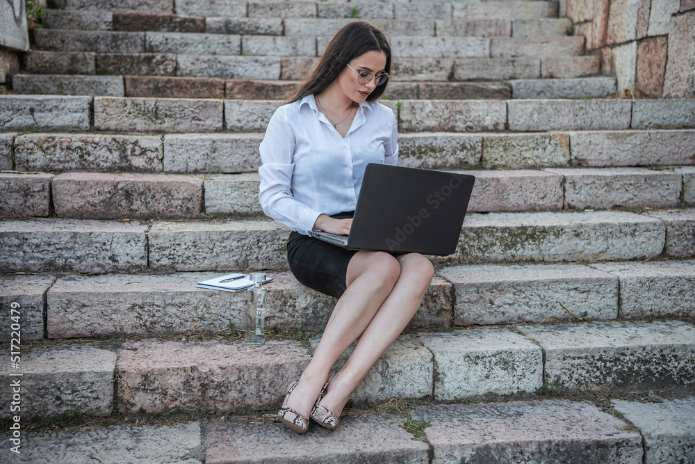 Business woman of the 21st century. A young girl works in the park. Flexible working hours. Modern young girl. Business woman of the 21st century. A young girl works in the park. Flexible working hours. Modern young girl.