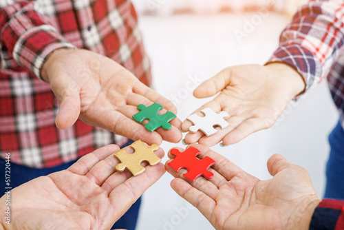 Close up Businesspeople hand holding jigsaw puzzle in a circle on the table, success and strategy concept.