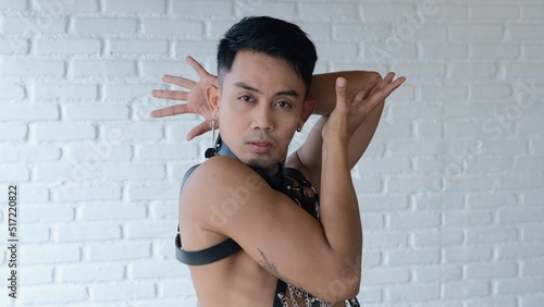 Tableau sur toile A sensual guy in a leather suit with chains expressively shows vogue poses