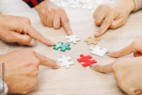 Close up Businesspeople hand holding jigsaw puzzle in a circle on the table, success and strategy concept.