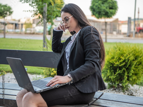 Business woman of the 21st century. A young girl works in the park. Flexible working hours.  Modern young girl.