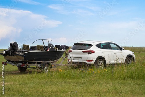 Картината върху платно An avid fisherman transports a boat with a passenger car using a boat trailer
