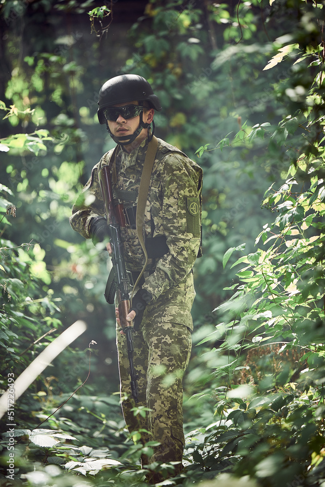 Ukrainian army soldier in uniform and helmet in the forest