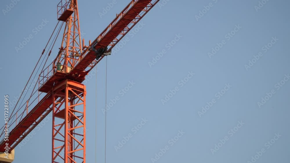 close-up of red crane pulley on blue sky working at dawn. 4k horizontal video close-up of red crane pulley on blue sky working at dawn. 4k horizontal video