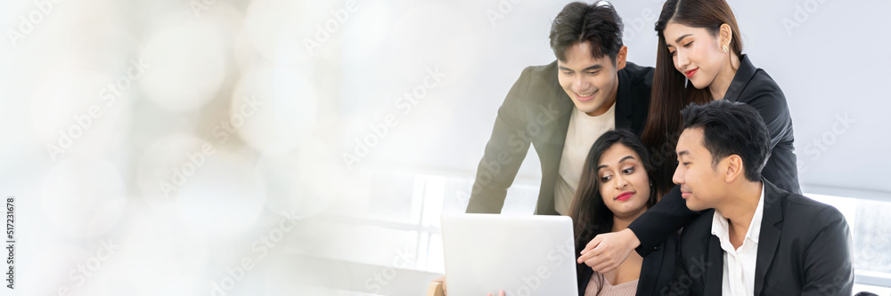 A group of young Asian businessman and women Talking and planning work happily and have fun. at the company's office web banner with copy space on left A group of young Asian businessman and women Talking and planning work happily and have fun. at the company's office web banner with copy space on left