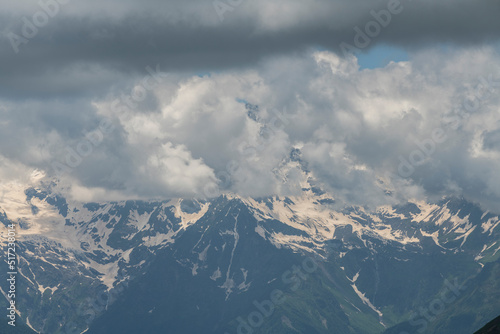 Clouds over the snow covered mountains. High mountains peak, winter landscape.