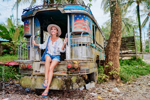 Traveling Asia. Young pretty woman in traditional philippines bus jeepney. photo