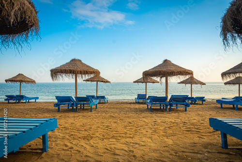 Fototapeta Naklejka Na Ścianę i Meble -  Liegen und Schirme an einem leeren Strand im Sommerurlaub 
