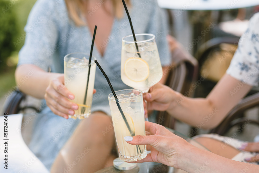 Friends having lemonade drinks on outdoors terrace. Summer lifestyle. - obrazy, fototapety, plakaty 