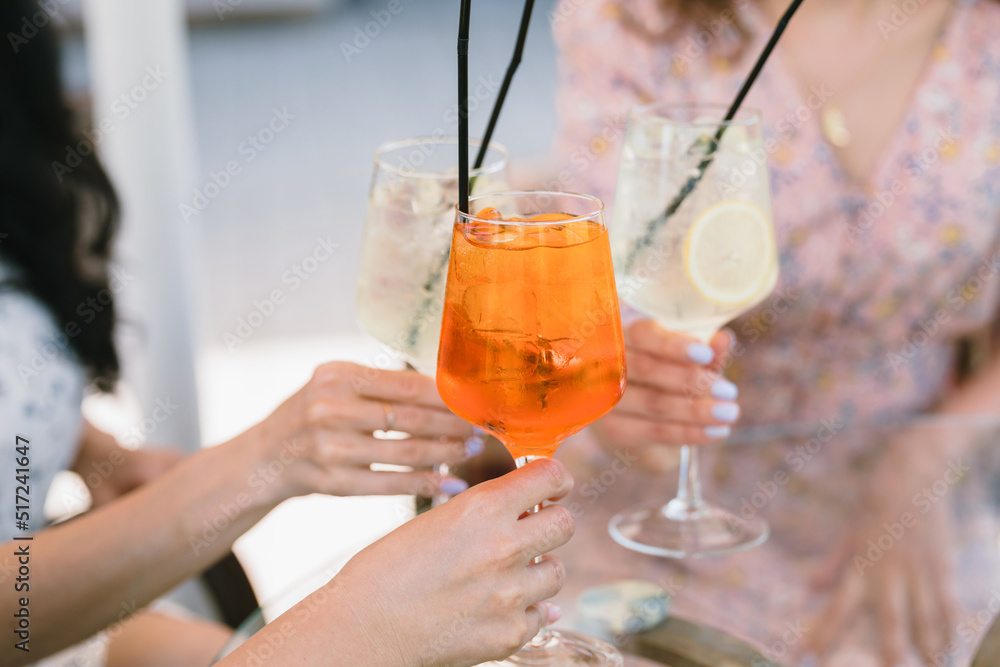 Women holding glasses of summer cocktails. Sunny summer day. Women holding glasses of summer cocktails. Sunny summer day.