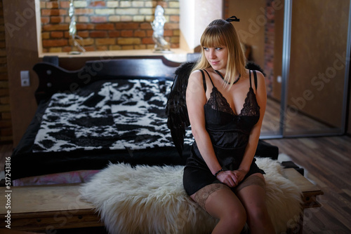 Foto beautiful girl in black lingerie with black angel wings in a loft interior