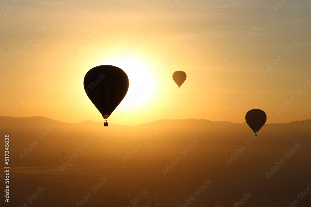 Fototapeta premium Hot-air balloons at sunrise over the mountains in Teotihuacan, Mexico