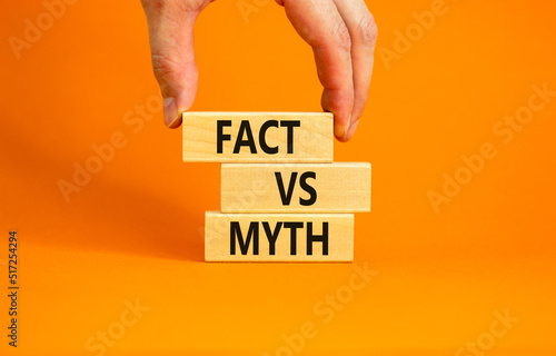 Fact vs myth symbol. Concept words Fact vs myth on wooden blocks on a beautiful orange table orange background. Businessman hand. Business, finacial and fact vs myth concept. Copy space. photo