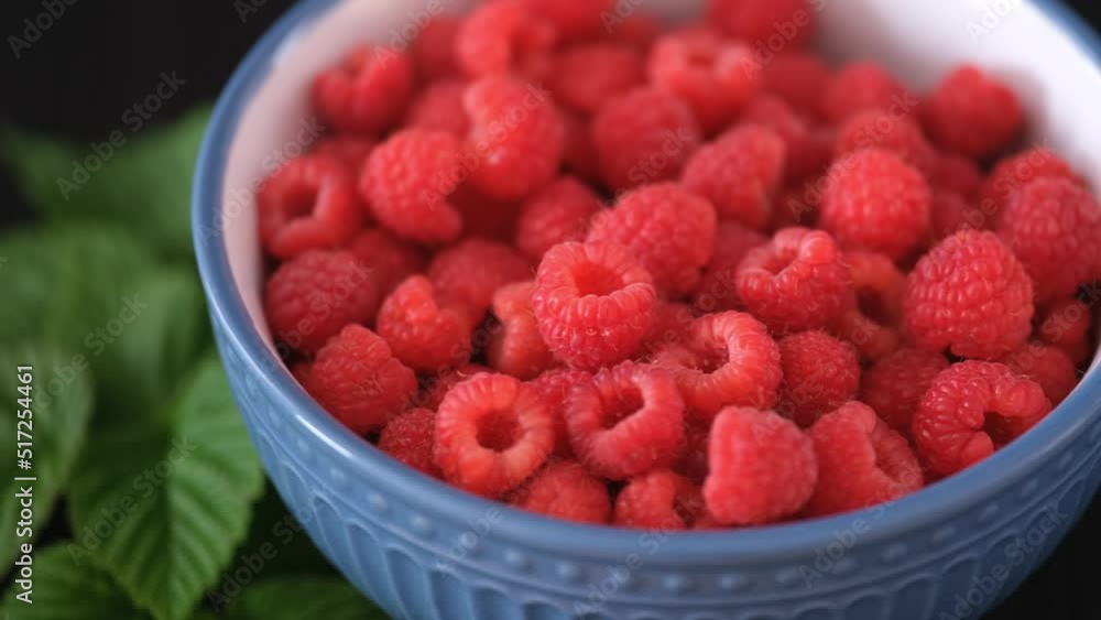 Fresh organic raspberries in a bowl. Low key. Close up. Fresh organic raspberries in a bowl. Low key. Close up.