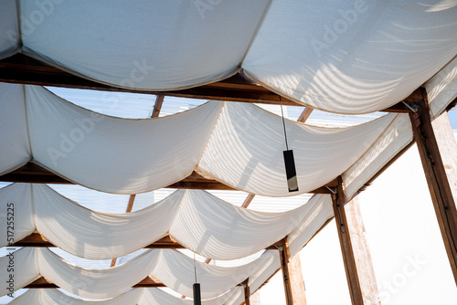 A hinged fabric roof, a summer patio, protection from the sun and heat, the interior of an outdoor cafe, white fabric on the ceiling, a restaurant in the desert.