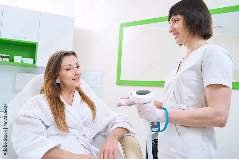 Fototapeta premium Patient and doctor talking about skin photorejuvenation procedure