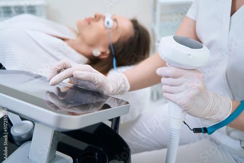 Doctor adjusts the apparatus for photorejuvenation of the skin photo