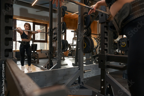 Sportswoman working out with bar during strength training