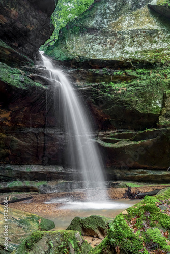 After spring rains, a beautiful ephemeral waterfall on Queer Creek plunges over a sandstone cliff recess in scenic Hocking Hills State Park in southeast Ohio.