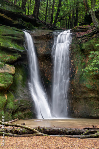 Fototapeta Naklejka Na Ścianę i Meble -  Rockstull Falls, a beautiful and secluded waterfall in the forest of the Hocking Hills region of southeast Ohio, splashes down a sandstone cliff after spring rains.
